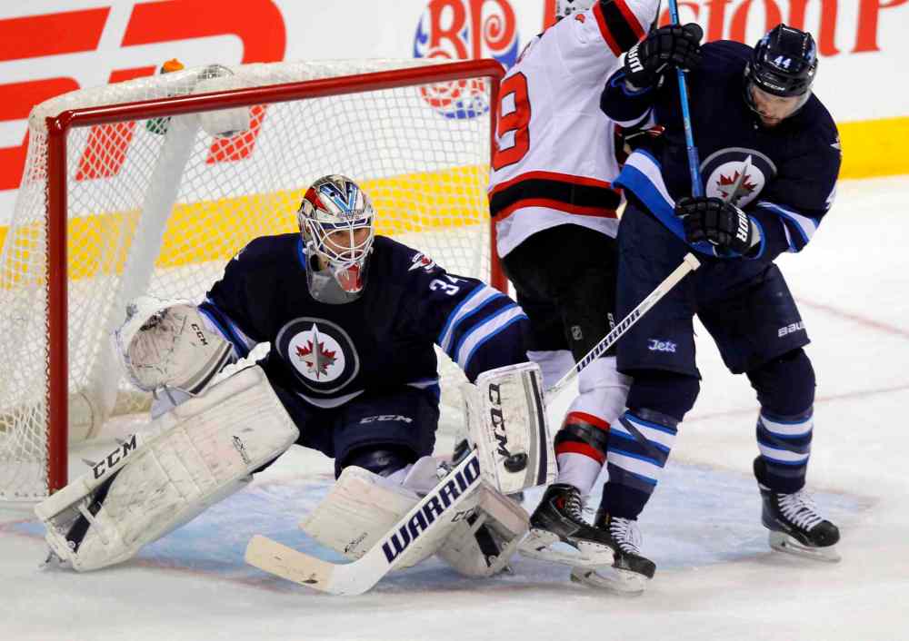 BORIS MINKEVICH / WINNIPEG FREE PRESS
Jets' blue-liner Zach Bogosian clears Devils' centre Travis Zajac from in front of Winnipeg goalie Michael Hutchinson Tuesday night.