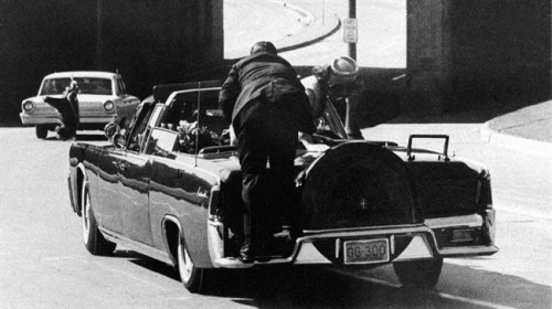 In this Friday, Nov. 22, 1963 file photo, President John F. Kennedy slumps down in the back seat of the Presidential limousine as it speeds along Elm Street toward the Stemmons Freeway overpass in Dallas after being fatally shot. THE CANADIAN PRESS/AP, James W. 