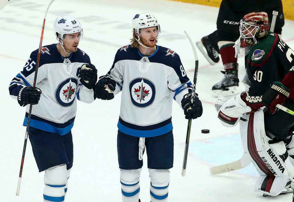 Winnipeg Jets left wing Kyle Connor, middle, celebrates his goal against Arizona Coyotes goaltender Calvin Pickard (30) as Jets center Mark Scheifele (55) joins Connor during the second period of an NHL hockey game Saturday, April 6, 2019, in Glendale, Ariz. (AP Photo/Ross D. Franklin)
