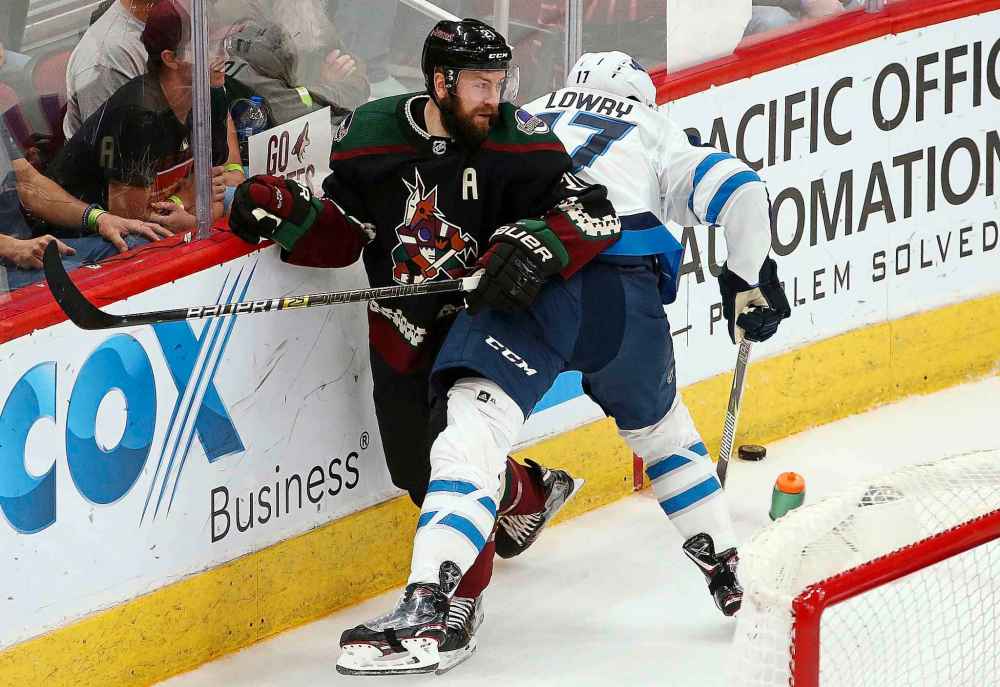 Arizona Coyotes center Derek Stepan (21) tangles with Winnipeg Jets center Adam Lowry, right, as they both go for the puck during the second period of an NHL hockey game Saturday, April 6, 2019, in Glendale, Ariz. (AP Photo/Ross D. Franklin)