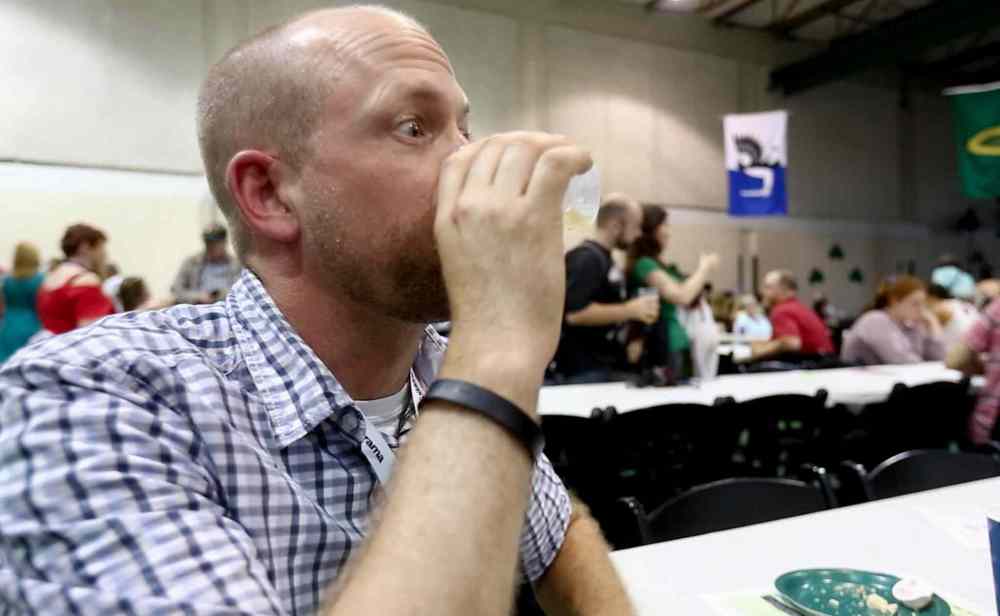 Ben Macphee-Sigurdson drinks Jameson's Whiskey at the Irish Pavilion, the first stop of his Folklorama drinks tour — also known as Ben's Global Bender. (Melissa Tait / Winnipeg Free Press)