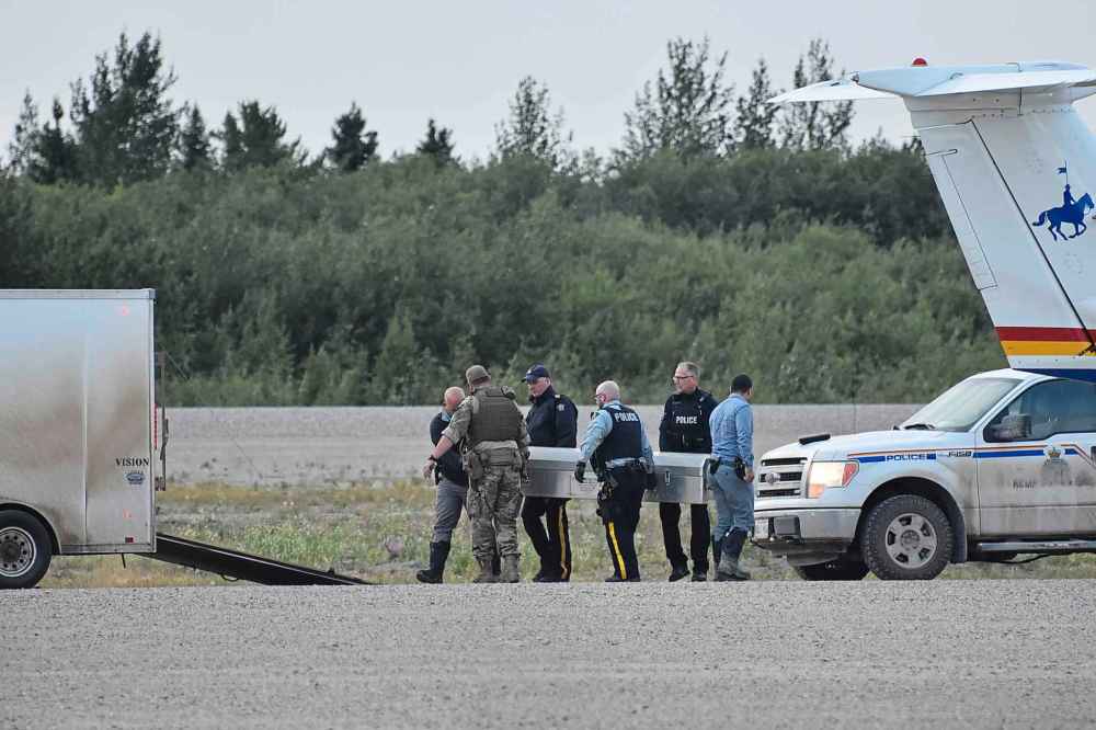 Two metal coffins containing the remains of two manhunt suspects were loaded on two separate RCMP planes at the Gillam airport on Aug. 7, 2019. An autopsy in Winnipeg will confirm their identity and cause of death. (Tessa Vanderhart / Winnipeg Free Press)
