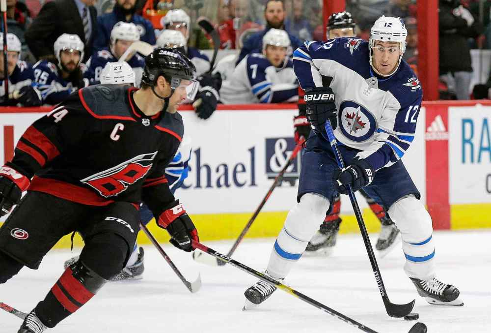 Winnipeg Jets' Kevin Hayes (12) looks to shoot while Carolina Hurricanes' Justin Williams defends during the second period of an NHL hockey game in Raleigh, N.C., Friday, March 8, 2019. Gerry Broome / The Associated Press