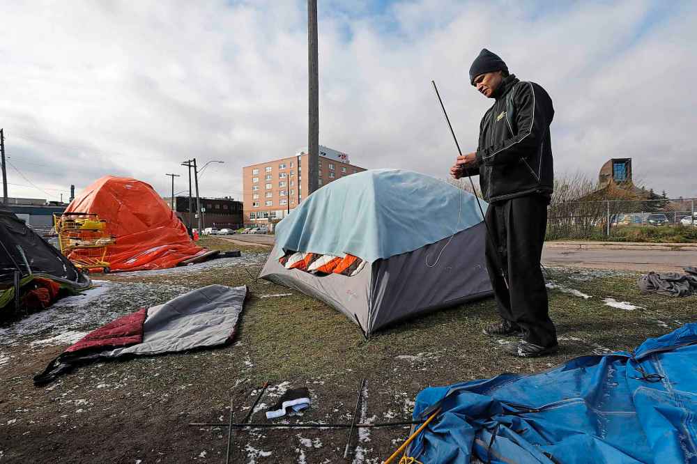 RUTH BONNEVILLE / WINNIPEG FREE PRESS
Johnny Guiboche, who has been homeless for many years, works on a tent that belongs to his god child near Thunderbird House, Monday.
