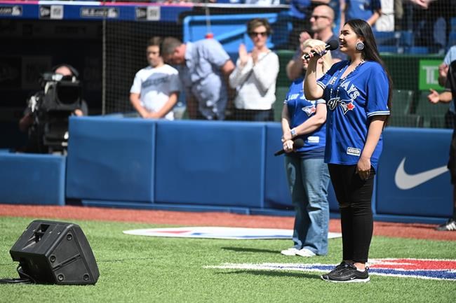 Kiya Bruno sings the Canadian national anthem before first inning MLB baseball action between the Toronto Blue Jays and the Kansas City Royals, in Toronto, Saturday, June 29, 2019. THE CANADIAN PRESS/Jon Blacker
