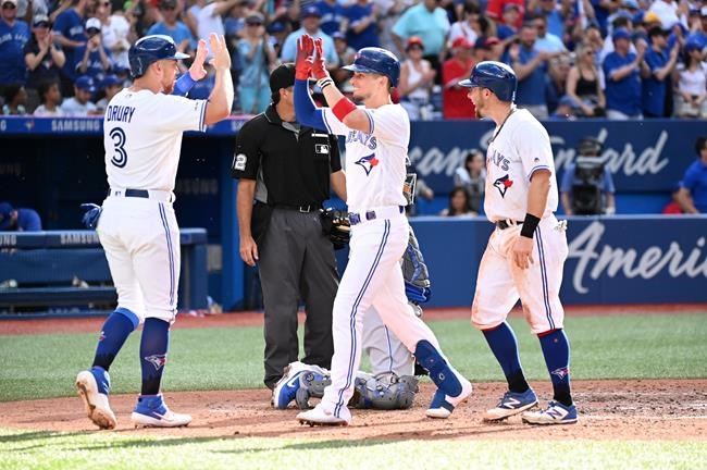 Toronto Blue Jays' Cavan Biggio, centre, celebrates hitting a grand slam with teammates Brandon Drury, left, and Eric Sogard during fifth inning MLB baseball action against the Kansas City Royals, in Toronto on Saturday, June 29, 2019. THE CANADIAN PRESS/Jon Blacker