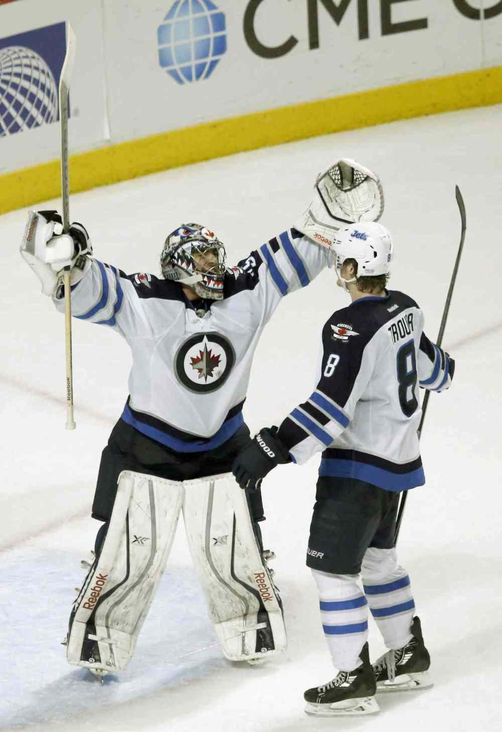 Charles Rex Arbogast / The Associated Press
Jets goalie Al Montoya celebrates the Jets' 3-1 win over the Blackhawks with Jacob Trouba.