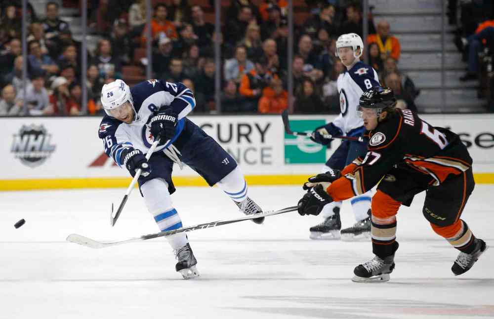 Jae C. Hong / The Associated Press
Winnipeg Jets' Blake Wheeler, left, passes the puck under pressure by Anaheim Ducks' Rickard Rakell during the first period.