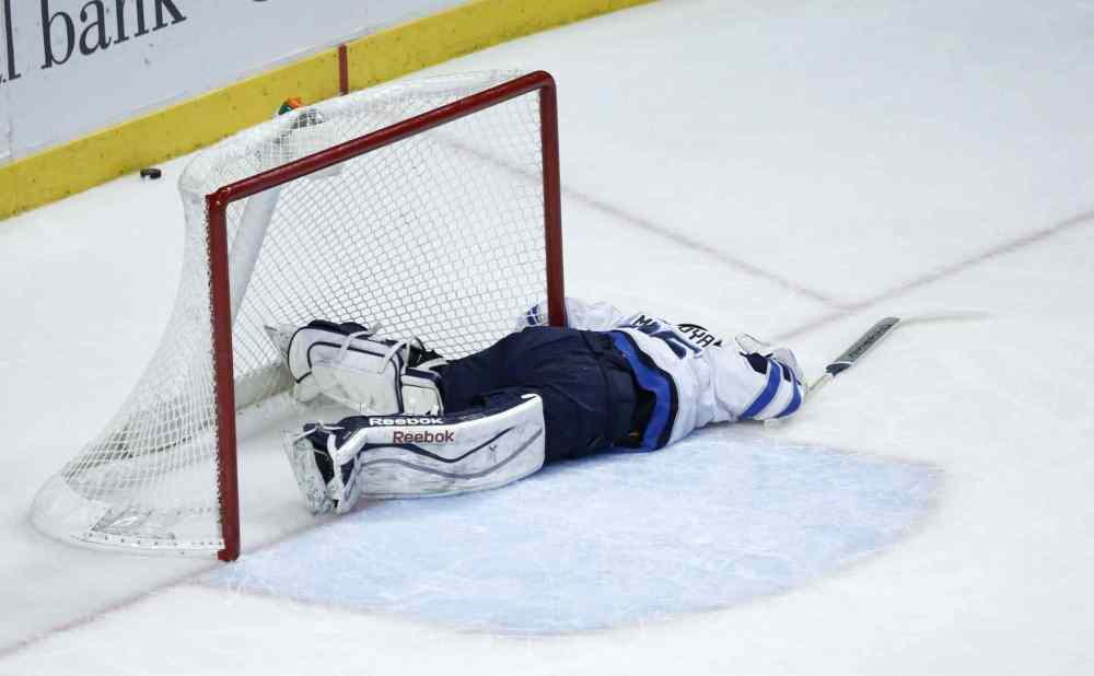 Charles Rex Arbogast / The Associated Press
Jets goalie Al Montoya lies on the ice after a collision with Blackhawks forward Marian Hossa.