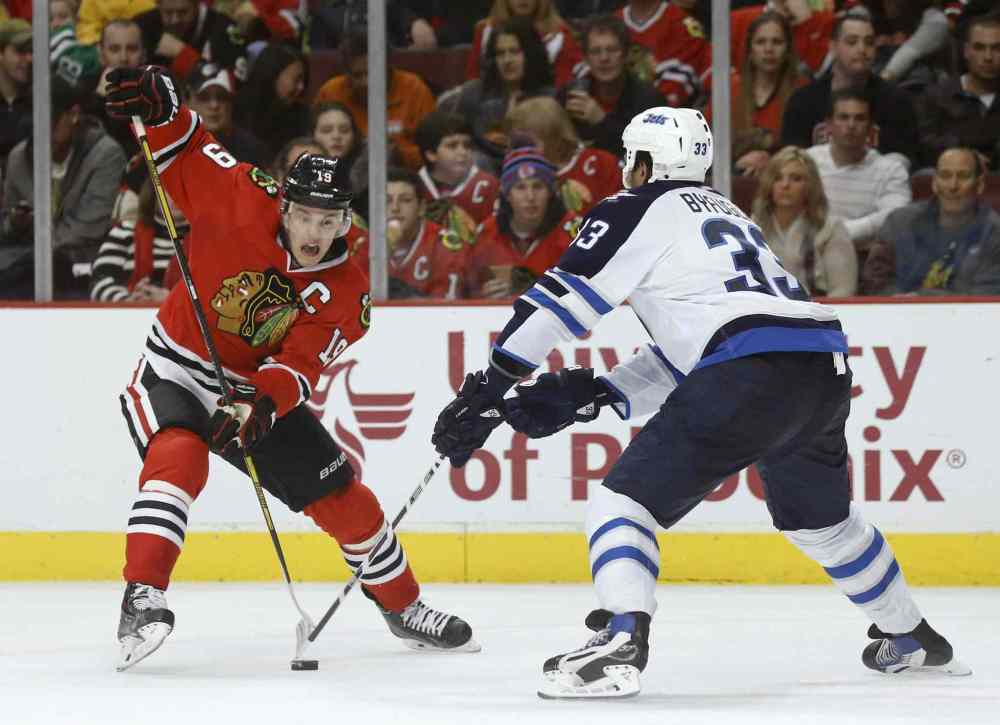 Charles Rex Arbogast / The Associated Press
Blackhawks captain Jonathan Toews tries to dangle past the Jets' Dustin Byfuglien. Buff as a forward has delivered obvious benefits