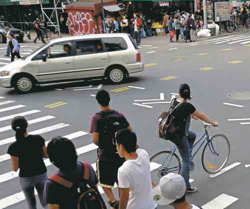 Pedestrians, cyclists and motorists share the street at an intersection in New York City.