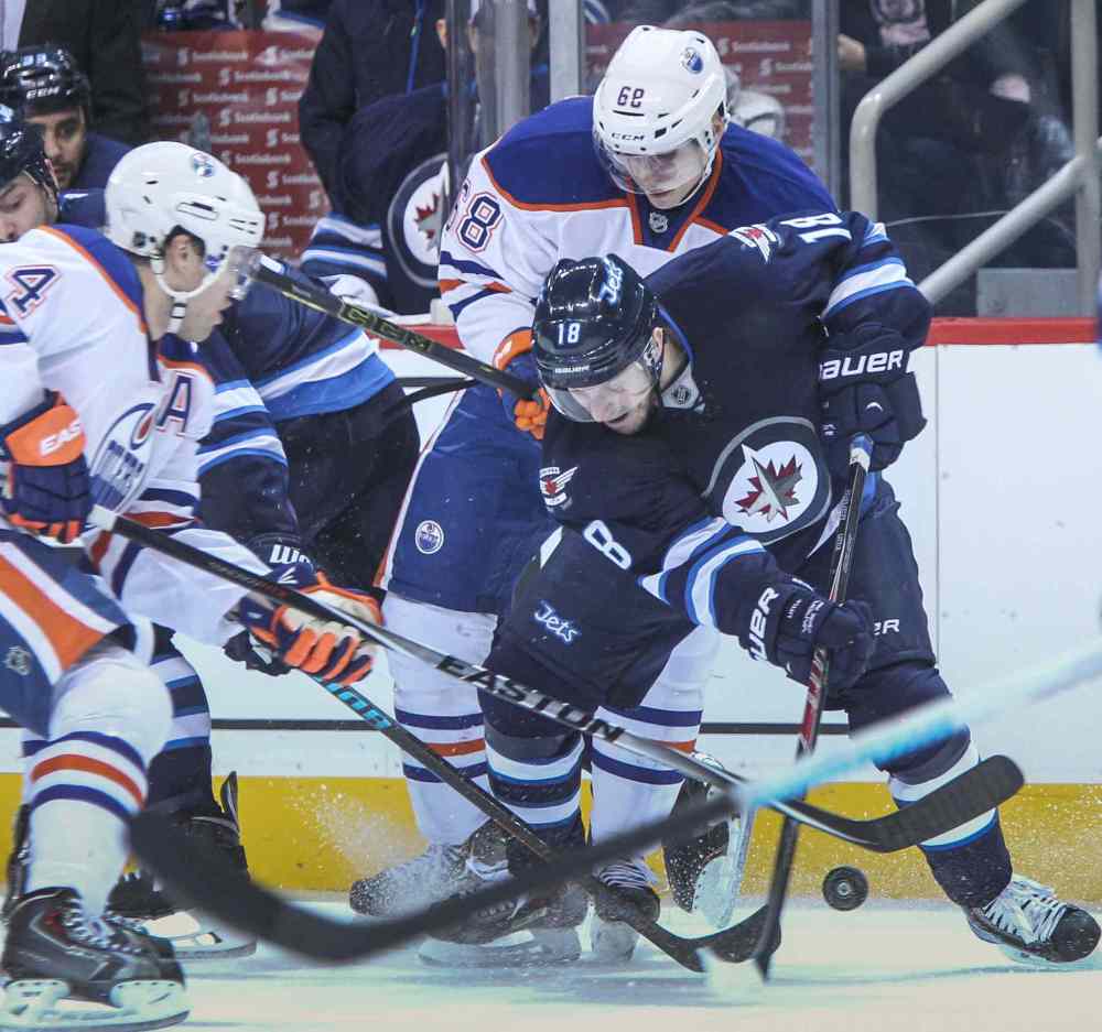 MIKE DEAL / WINNIPEG FREE PRESS
Winnipeg Jets' Bryan Little (18) tries to get control of the puck from Edmonton Oilers' Taylor Hall (4) and Tyler Pitlick (68) during NHL action in Winnipeg Wednesday at MTS Centre. 141203 - Wednesday, December 03, 2014 - (MIKE DEAL / WINNIPEG FREE PRESS)