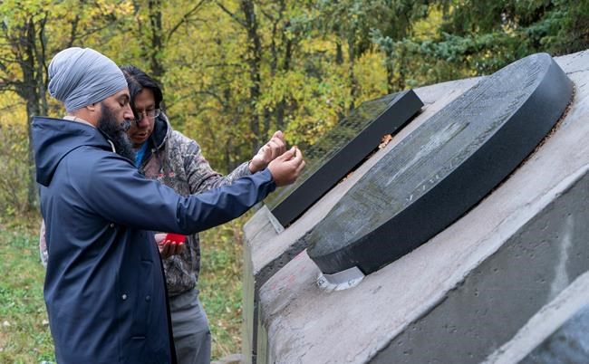 NDP Leader Jagmeet Singh makes an offering of tobacco at the monument to the local victims of residential schools on the Grassy Narrows First Nation in northwestern Ontario on Saturday, October 5, 2019. THE CANADIAN PRESS/Paul Chiasson