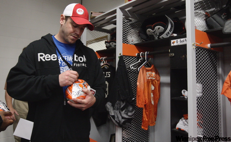 DARRYL DYCK / the canadian press
Buck Pierce signs a football for a teammate while cleaning out his locker at the team's practice facility on Nov. 23, 2009, a day after the B.C. Lions were defeated by the Montreal Alouettes in the CFL's eastern final.
