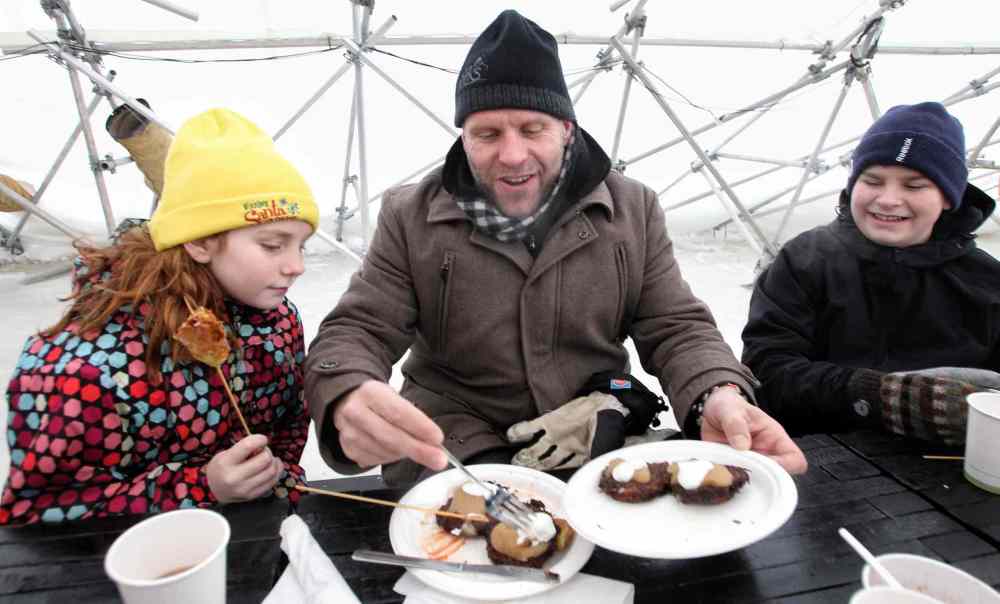 Mike Deal / Winnipeg Free Press
Kerry LeBlanc serves breakfast latkes to his daughter, Kwynn (left), and son, Karter, during brunch at the River Pop-up restaurant located on the Assiniboine River at The Forks.
