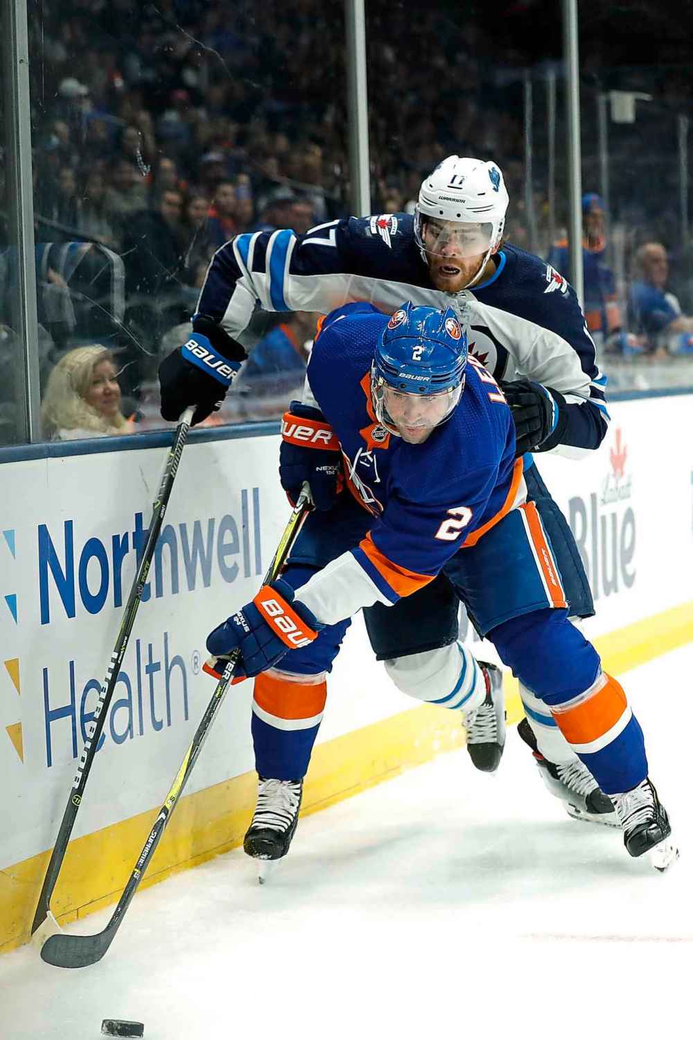 NMICHAEL OWENS / THE ASSOCIATED PRESS
ew York Islanders defenseman Nick Leddy (2) and Winnipeg Jets center Adam Lowry (17) reach for the puck during the first period of an NHL hockey game Sunday, Oct. 6, 2019, in Uniondale, N.Y.