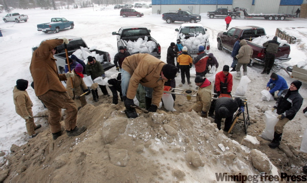 WAYNE GLOWACKI / WINNIPEG FREE PRESS
Firefighters and volunteers fill sandbags at the St. Clements Fire Hall Thursday morning.