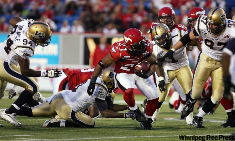 Grant Black / Postmedia
Calgary Stampeders running back Joffrey Reynolds splits the Winnipeg Blue Bombers defense in the second half of CFL action in Calgary Saturday.