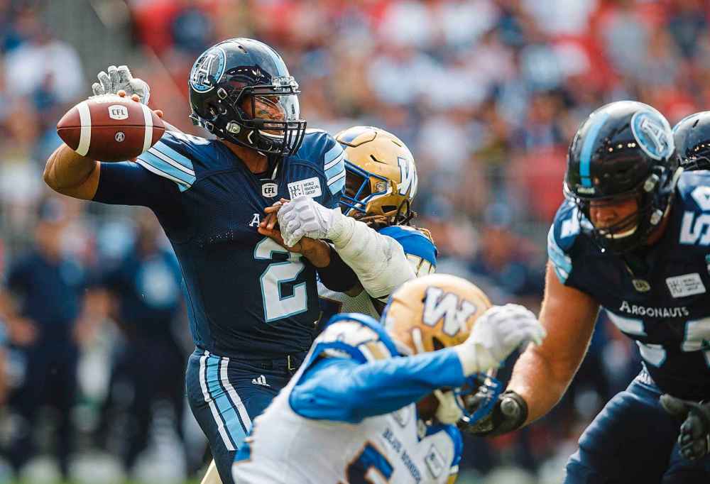 Toronto Argonauts quarterback James Franklin passes under pressure from Winnipeg Blue Bombers' Cory Johnson during the first half of CFL football action in Toronto, Saturday July 21, 2018.