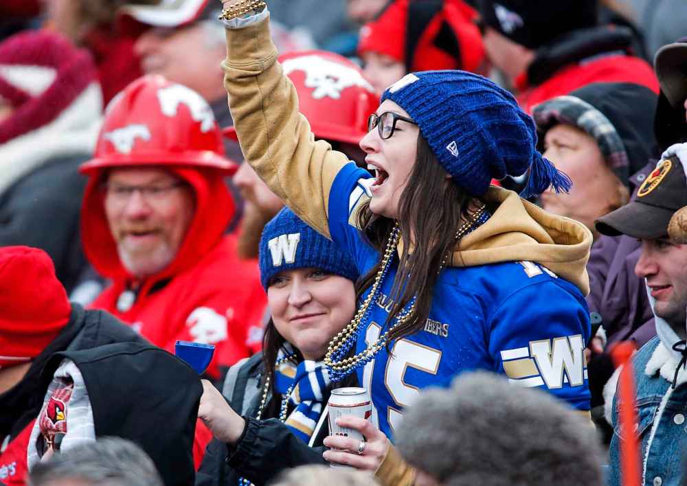 JEFF MCINTOSH / THE CANADIAN PRESS
A Winnipeg Blue Bombers fan cheers during first half CFL West final football action against the Calgary Stampeders, in Calgary, Sunday, Nov. 18, 2018.