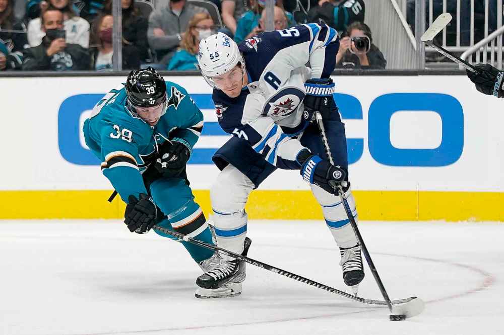 CP
San Jose Sharks center Logan Couture, left, reaches for the puck next to Winnipeg Jets center Mark Scheifele during the first period. (Jeff Chiu / The Associated Press)