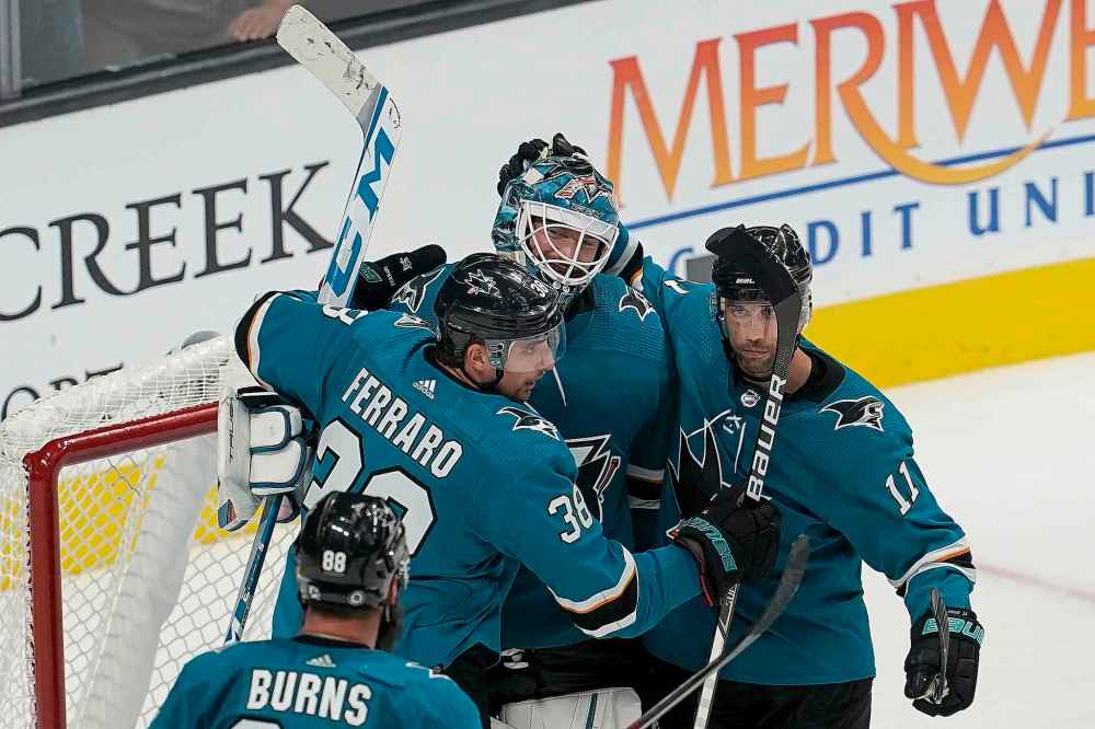 CP
San Jose Sharks goaltender Adin Hill, middle, is congratulated by Mario Ferraro, left, and Andrew Cogliano (11) after the Sharks defeated the Winnipeg Jets 4-3 in an NHL hockey game in San Jose, Calif., Saturday, Oct. 16, 2021. (Jeff Chiu / The Associated Press)