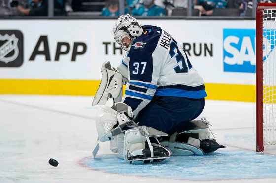 CPWinnipeg Jets goaltender Connor Hellebuyck defends against a shot by the San Jose Sharks during the first period. (Jeff Chiu / The Associated Press)