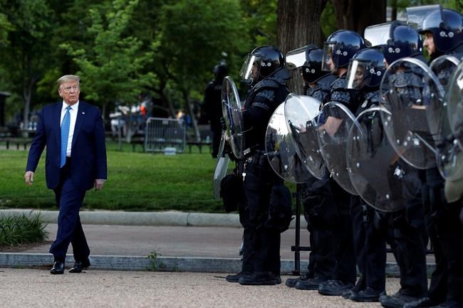 President Donald Trump walks past police in Lafayette Park after he visited outside St. John's Church across from the White House Monday, June 1, 2020, in Washington. Part of the church was set on fire during protests on Sunday night. (AP Photo/Patrick Semansky)