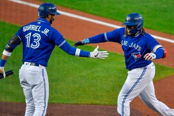Toronto Blue Jays' Vladimir Guerrero Jr., right, is congratulated by Lourdes Gurriel Jr. after hitting a solo home run against the New York Yankees during the second inning of a baseball game in Buffalo, N.Y., Thursday, Sept. 24, 2020. (AP Photo/Adrian Kraus)
