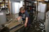 Tim Smith/The Brandon Sun
Dana Burgess helps haul equipment out of the flooded basement of the Corner Stone Grill in Minnedosa on Tuesday. In the wake of Sunday's severe storm activity the restaurant was flooded with several feet of water in the basement, where much of the restaurant equipment was. The water level fell overnight allowing the owners and several volunteers to begin hauling out ruined equipment and food as well as begin to clean up the mess caused by the floodwater.