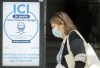 A woman wears a face mask as she walks by a sign advising of the mandatory wearing of masks and face coverings in Montreal, Monday, September 21, 2020, as the COVID-19 pandemic continues in Canada and around the world. THE CANADIAN PRESS/Graham Hughes