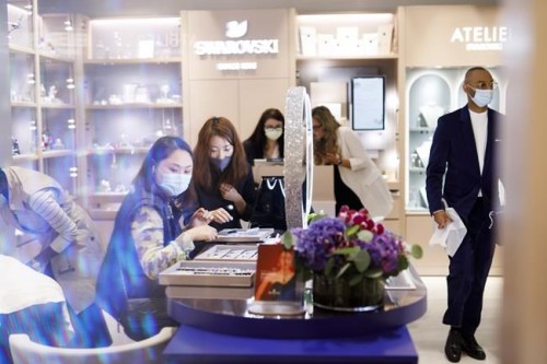 Jean Gu, second from left, helps a customer look over jewlery at Swarovski's newly opened store in Sherway Gardens Mall in Toronto, Friday, Sept. 25, 2020. THE CANADIAN PRESS/Cole Burston