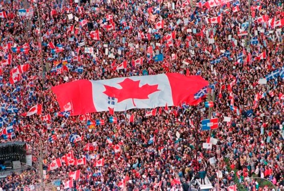 A large Canadian flag is passed through a crowd in this Friday, Oct. 27, 1995 file picture, as thousands streamed into Montreal from all over Canada to join Quebecers rallying for national unity three days before a referendum that could propel Quebec toward secession. Twenty-five years ago today, Quebec came within inches of separating from Canada. THE CANADIAN PRESS/Ryan Remiorz