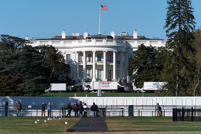People look at the South Lawn of the White House, Monday, Nov. 2, 2020, in Washington, the day before the U.S. election. A towering barrier against protesters surrounds the White House as Americans deliver a final verdict on their next commander-in-chief. THE CANADIAN PRESS/AP-Jacquelyn Martin