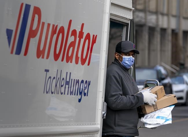 A Purolator driver wears a mask as he makes deliveries in Toronto, March 24, 2020. Purolator expects to deliver 46 million packages through its peak season this year, which runs through most of November and part of December, CEO John Ferguson said. THE CANADIAN PRESS/Frank Gunn