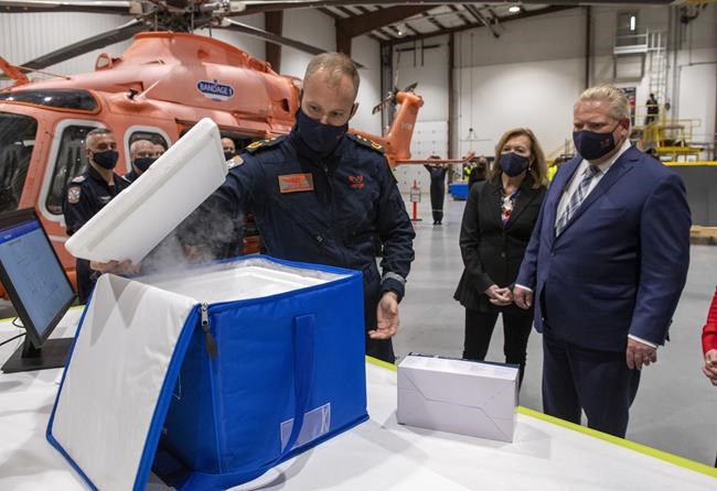 ORNGE Chief Paramedic Justin Smith, left, demonstrates a Remote Cold Storage Monitoring insulated container for Ontario Premier Doug Ford, right, and Health Minister Christine Elliott at Toronto Island Airport, Wednesday, Dec. 16, 2020. Ontario says it expects to receive approximately 53,000 doses of the newly approved Moderna COVID-19 vaccine by the end this month. THE CANADIAN PRESS/Frank Gunn
