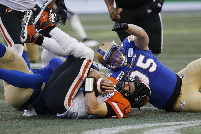 Winnipeg Blue Bombers' Craig Roh (93) and Jake Thomas (95) sack BC Lions quarterback Mike Reilly (13) after he recovers his own fumble during the first half of CFL action in Winnipeg, Thursday, August 15, 2019. Thomas will return for his ninth season with Winnipeg.THE CANADIAN PRESS/John Woods