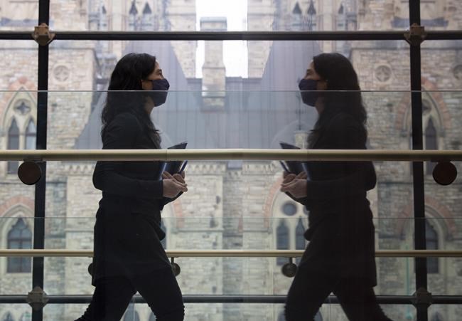Chief public health officer Dr. Theresa Tam is reflected in a wall as she leaves a news conference Tuesday Jan. 5, 2021 in Ottawa. THE CANADIAN PRESS/Adrian Wyld