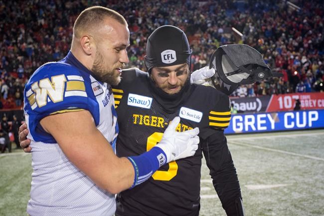 Hamilton Tiger-Cats quarterback Dane Evans, right, is comforted by Winnipeg Blue Bombers Thiadric Hansen following the CFL Grey Cup in Calgary, Sunday, Nov. 24, 2019. Hansen has signed a one-year extension with the Winnipeg Blue Bombers. THE CANADIAN PRESS/Jeff McIntosh