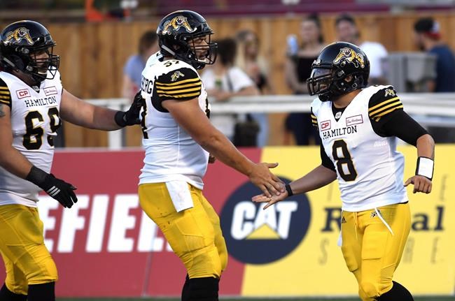 Hamilton Tiger-Cats quarterback Jeremiah Masoli (8) celebrates a conversion against the Ottawa Redblacks with Brandon Revenberg (57) and Landon Rice (60) during the first half of a pre-season CFL football game in Ottawa on Thursday, June 8, 2017. THE CANADIAN PRESS/Justin Tang