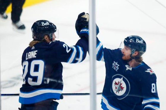 Winnipeg Jets' Patrik Laine (29) and Kyle Connor (81) celebrate Laine’s goal during opening game first period NHL action against the Calgary Flames, in Winnipeg, Thursday, Jan. 14, 2021. Laine scored his second goal of the game in overtime, and the Winnipeg Jets started their season with a 4-3 win over the Calgary Flames Thursday. THE CANADIAN PRESS/John Woods
