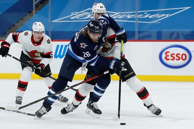 Winnipeg Jets' Blake Wheeler (26) attempts to get past Ottawa Senators' Erik Gudbranson (44) during second period NHL action in Winnipeg on Saturday, January 23, 2021. THE CANADIAN PRESS/John Woods