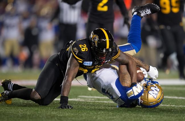 Hamilton Tiger-Cats' Cariel Brooks tackles Winnipeg Blue Bombers' Darvin Adams during first half football action in the 107th Grey Cup in Calgary, Alta., Sunday, November 24, 2019. he Hamilton Tiger-Cats have re-signed American defensive back Cariel Brooks. THE CANADIAN PRESS/Todd Korol