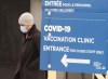 A man walks past the COVID-19 vaccination site at Maimonides long term care facility Wednesday, January 13, 2021 in Montreal. THE CANADIAN PRESS/Ryan Remiorz