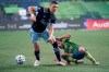 Vancouver Whitecaps midfielder David Milinkovic, left, looks to pass the ball as Seattle Sounders midfielder Nicolas Lodeiro, right, goes down during the first half of an MLS soccer match on October 3, 2020, in Seattle. THE CANADIAN PRESS/AP, Ted S. Warren