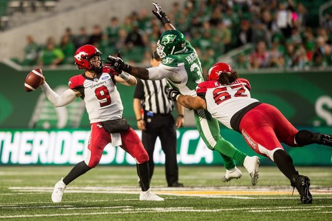 Calgary Stampeders quarterback Nick Arbuckle (9) attempts to throw the ball under pressure from Saskatchewan Roughriders defensive lineman Charleston Hughes (39) during first half CFL action in Regina on Saturday, July 6, 2019. The Calgary Stampeders defeated the Saskatchewan Roughriders 37-10. THE CANADIAN PRESS/Matt Smith