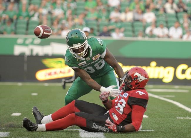 Saskatchewan Roughriders linebacker Alexandre Chevrier gets tangled up with the Calgary Stampeders defensive back Brandon Smith during first half pre-season CFL action in Regina on June 8, 2018. THE CANADIAN PRESS/Mark Taylor