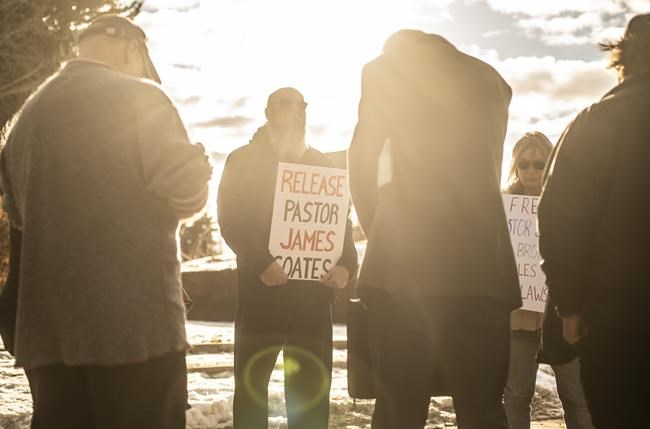 Supporters pray outside court in Stony Plain, Alta., on Wednesday, Feb. 24, 2021, as a trial date was set for Pastor James Coates of GraceLife Church. He is charged with holding Sunday services in violation of Alberta's COVID-19 rules and with breaking conditions of his bail release. THE CANADIAN PRESS/Jason Franson
