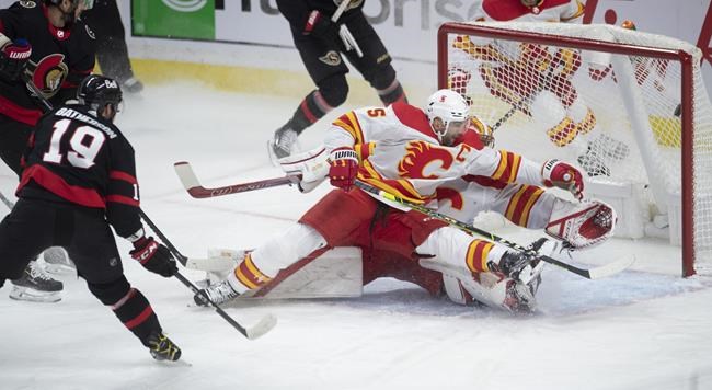 Calgary Flames defenceman Mark Giordano tries to help goaltender David Rittich stop a shot from Ottawa Senators right wing Drake Batherson during first-period NHL action Thursday, February 25, 2021 in Ottawa. THE CANADIAN PRESS/Adrian Wyld