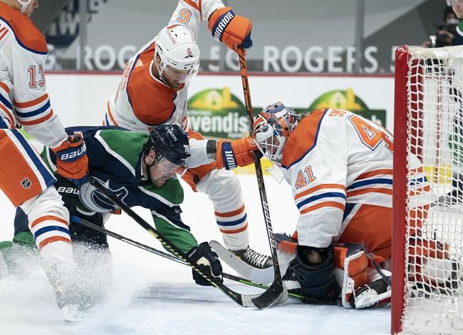 Edmonton Oilers defenceman Adam Larsson (6) tries to stop Vancouver Canucks left wing Tanner Pearson (70) from getting a shot on goaltender Mike Smith (41) during second-period NHL action in Vancouver, Thursday, February 25, 2021. THE CANADIAN PRESS/Jonathan Hayward